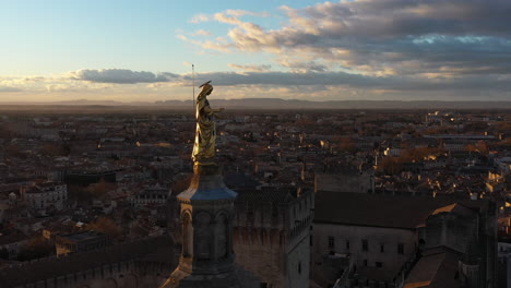 Golden-virgin-mary-statue-aerial-shot-Avignon-Palais-des-Papes-France-sunrise